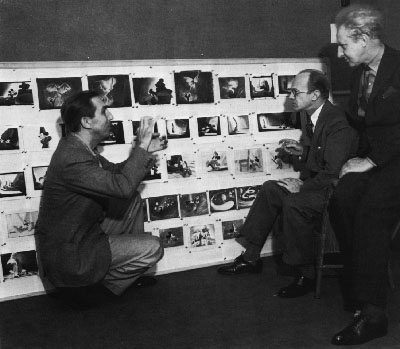 1939: Walt with narrator Deems Taylor and conductor Leopold Stokowski in front of a story board for The Sorcerers Apprentice